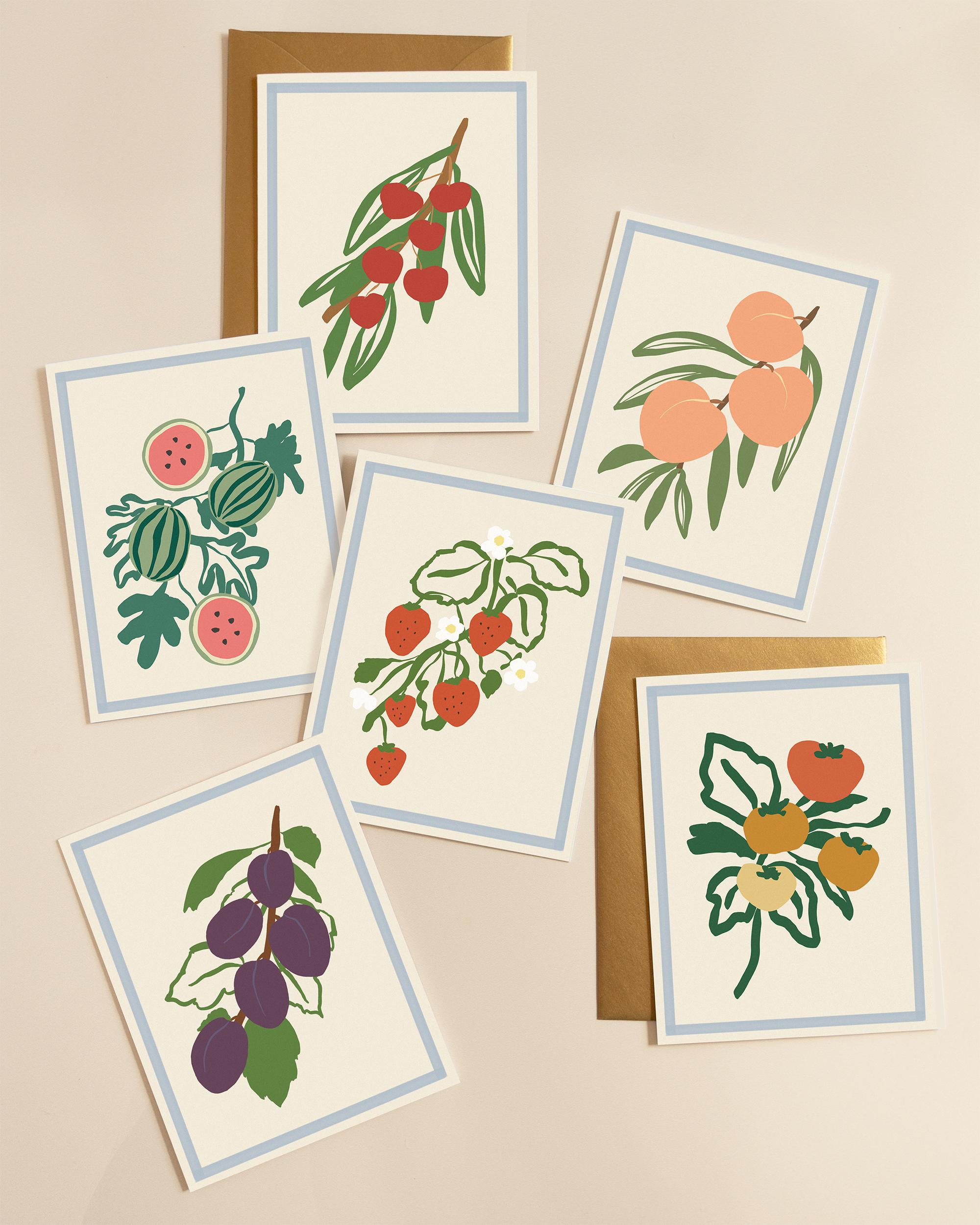 Set of greeting cards with fruit illustrations paired with gold envelopes